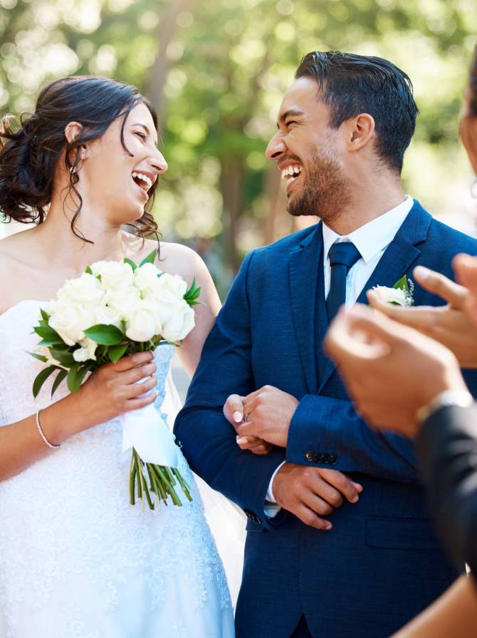 Happy bride and groom laughing and looking joyful after wedding ceremony and ready to celebrate wit.